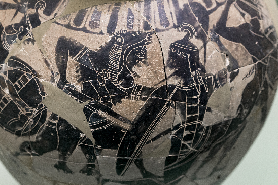 A vase painting from c. 570 BC showing a fight between Heracles and an Amazon. The Amazon is wearing Greek attire (chiton, horsecrest helmet, and round shield). Courtesy of the Rhodos Archaeological Museum.